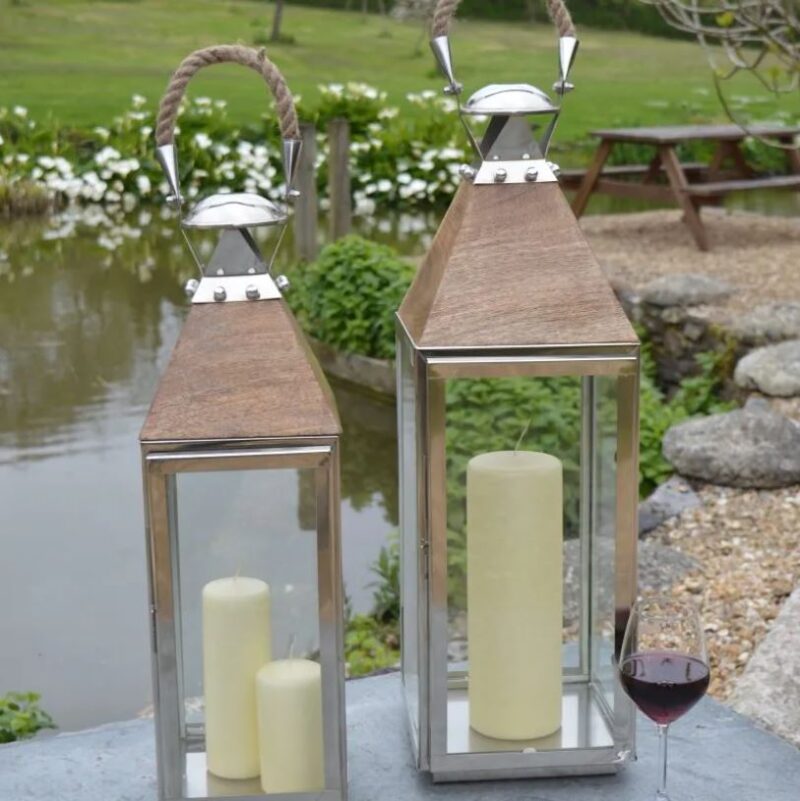 Silver lantern outdoors by pond with glass of wine