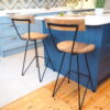 Industrial bar stools next to kitchen island with chopping board