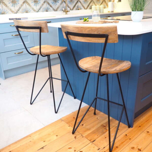Industrial bar stools next to kitchen island with chopping board