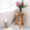 rustic wood side table with vase of flowers in bathroom