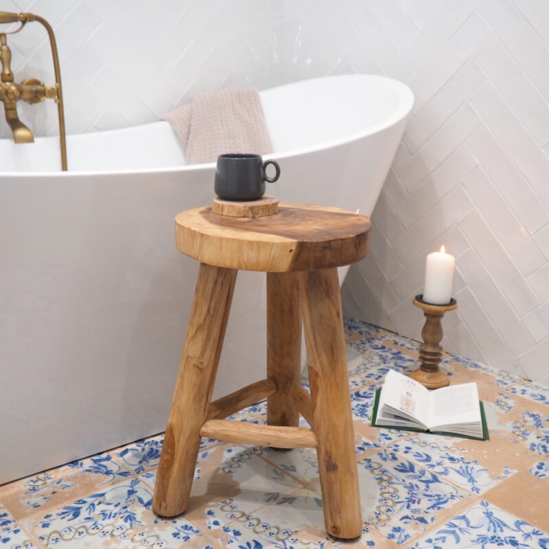 Rustic wooden stool with wood coaster and coffee cup in bathroom