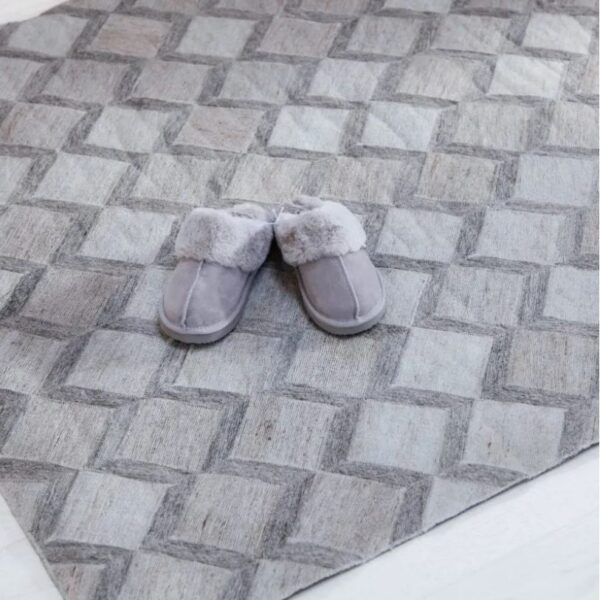 Close up of grey carpet rug Isabella with grey slippers on top