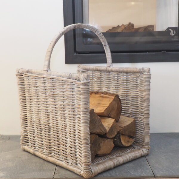 wicker log basket for wood logs, on tiled floor next to fireplace