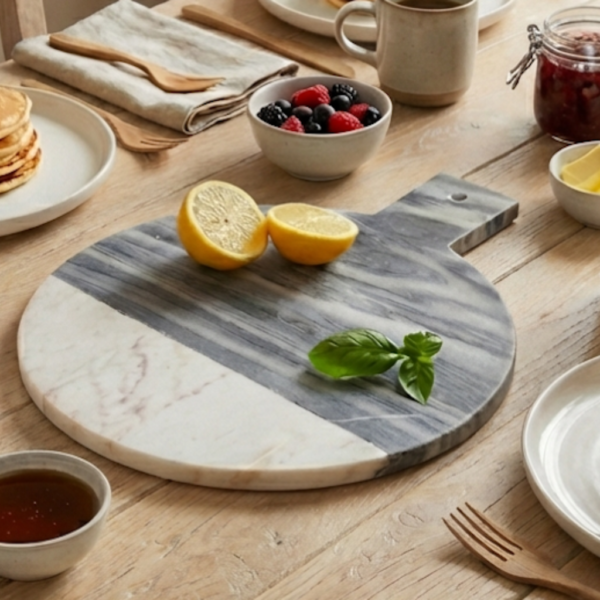 marble round chopping board on table in kitchen with coffee, pancakes, fruit