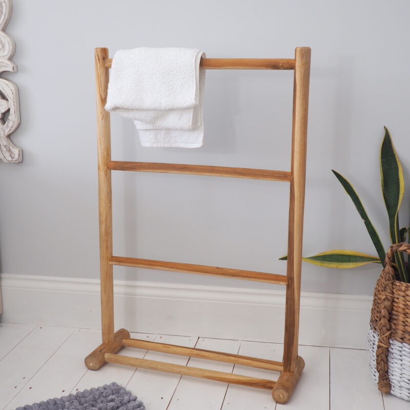 Wooden towel rack in bathroom with towel and plant