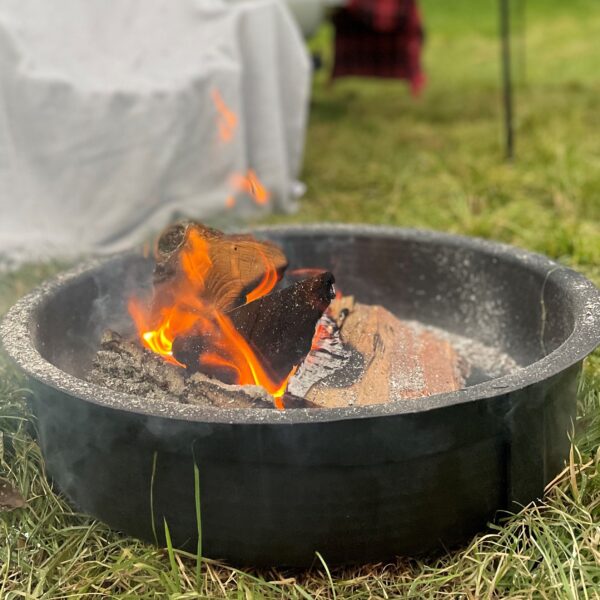 Tabletop fire pit black with burning logs outside