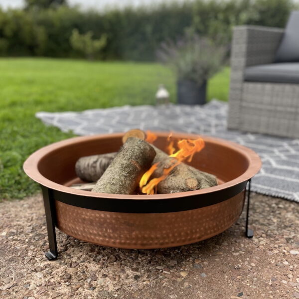 Garden fire pit outdoors in garden setting with rug and chair