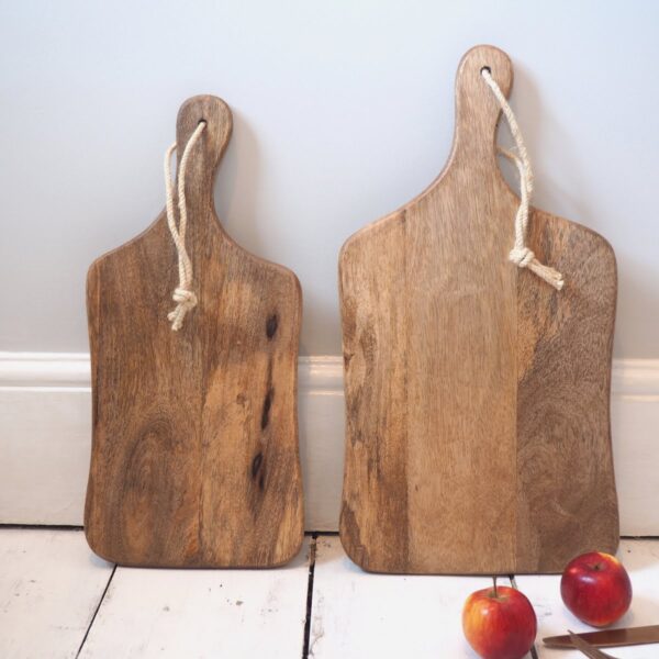 Natural wood chopping boards on white wooden floor with apples