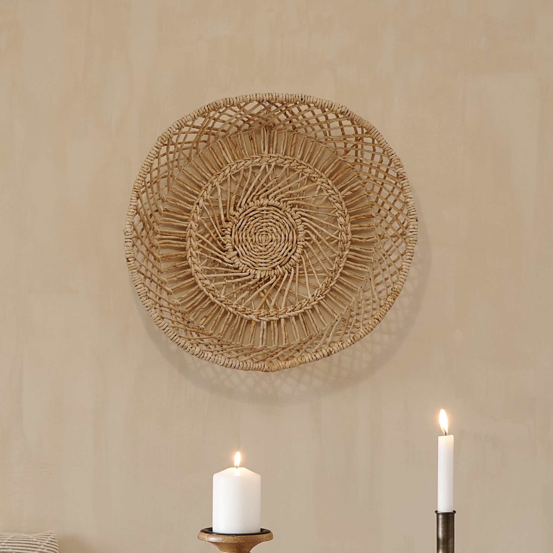 Wicker Wall Basket on wall with white candles underneath