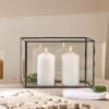 Black metal votive on table with candles and white placemats