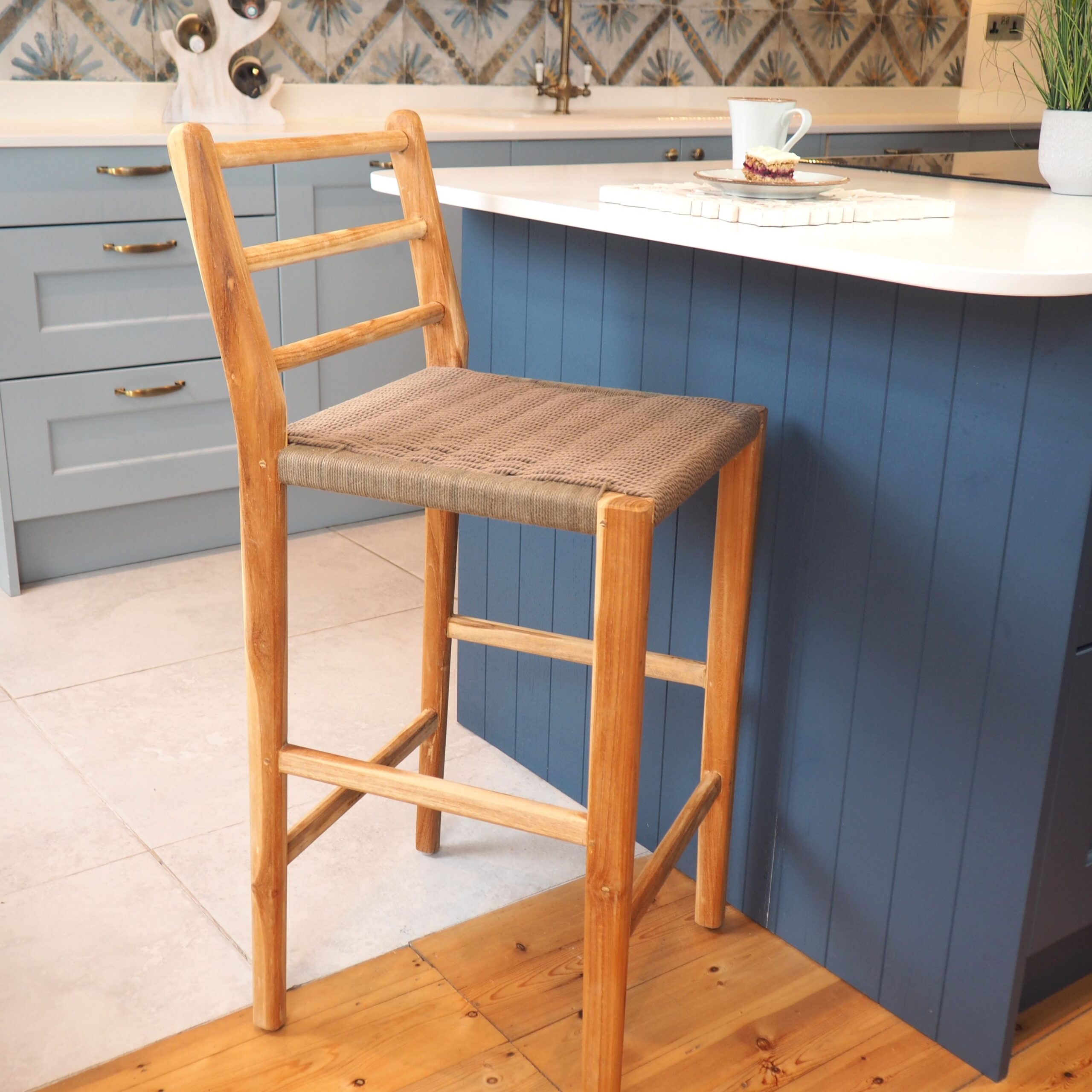 Natural wicker stool in front of blue kitchen island