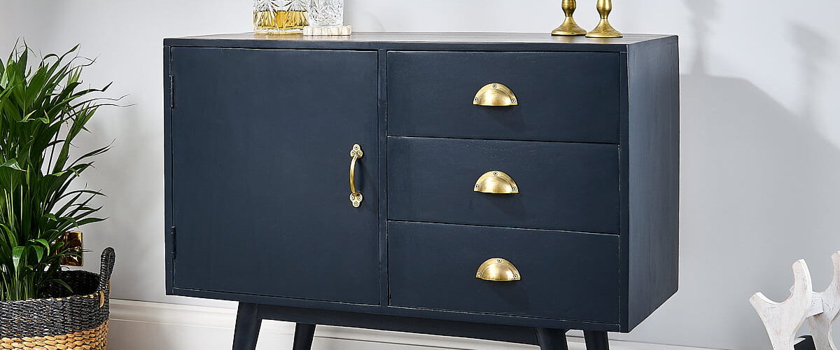 Navy blue sideboard on white wooden floor with rug, wine rack and plant