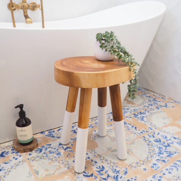 small rustic wooden stool in bathroom by bath