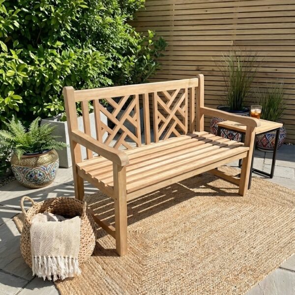 wood garden bench on garden patio with wicker rug and plant