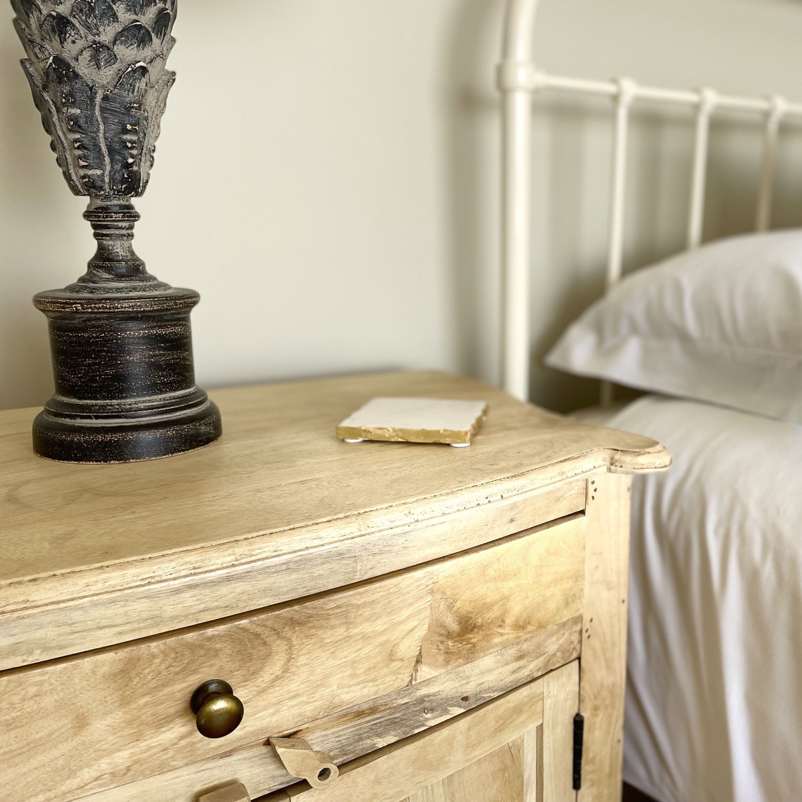 Eden bedside table next to bed with lamp and coaster