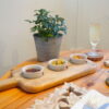 Wooden tapas board with bowls on table