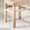 close up of rattan dining chair on white floor