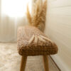 close up wooden hallway bench with wicker seat