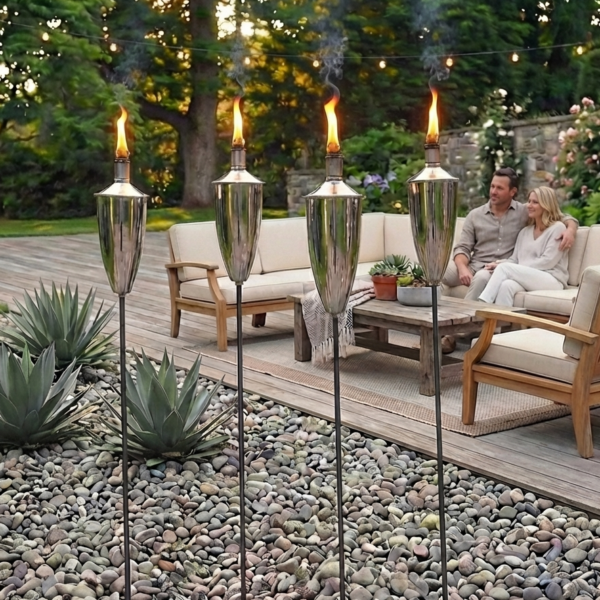 silver patio torches by decking with couple sat on garden sofa