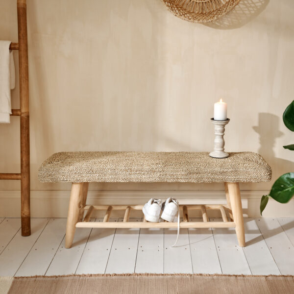 Seagrass wicker bench on wooden floor with wooden candle, shoes on the shelf and bamboo towel ladder