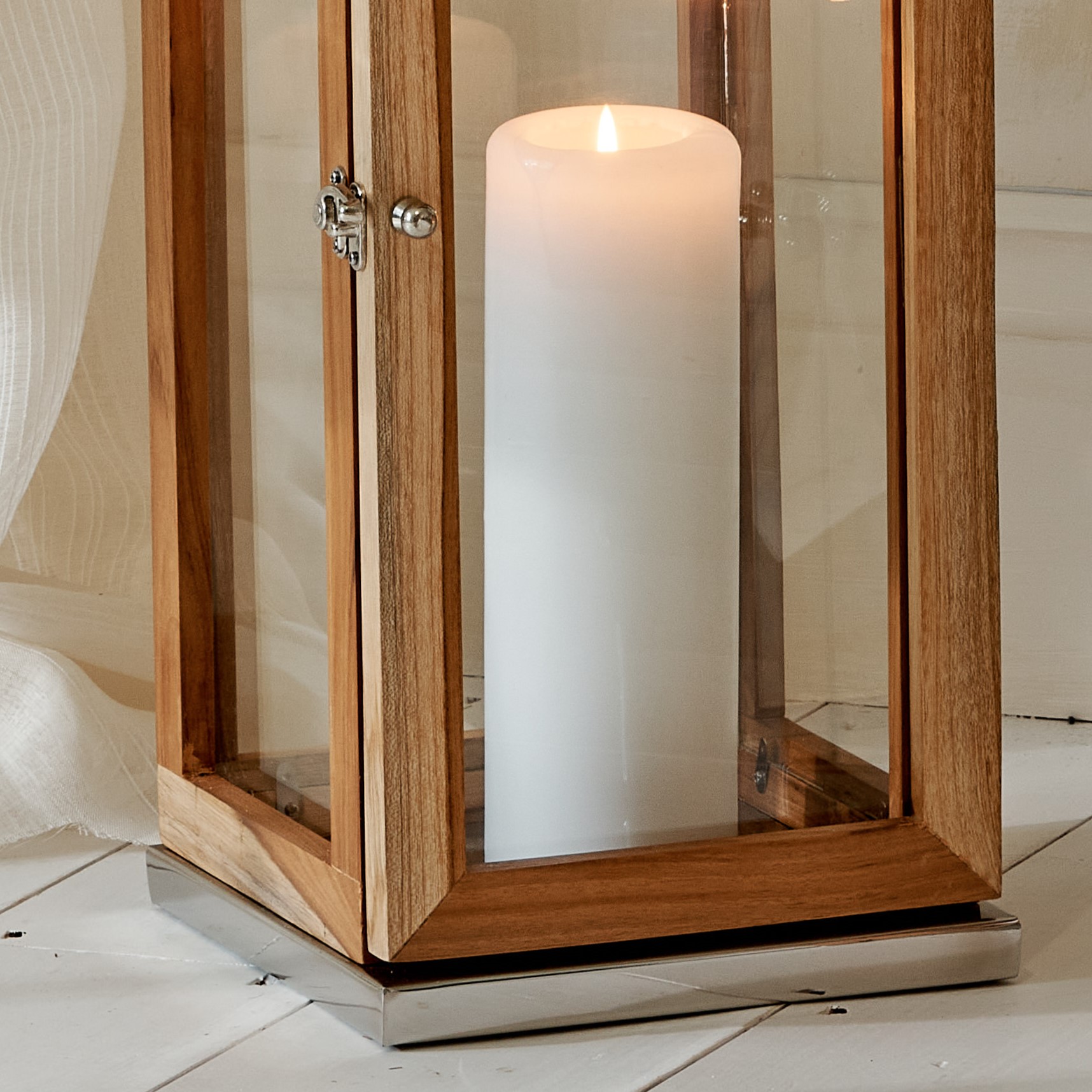 Close up of Mango wood and stainless steel candle lantern base with white pillar candle
