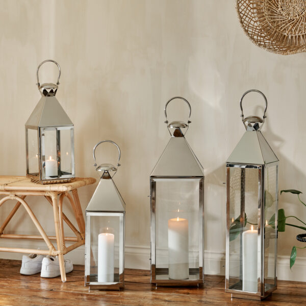 Set of 4 tall metal lanterns on wooden floor and bamboo bench