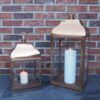 Rose gold candle lanterns on slate floor in front of brick wall