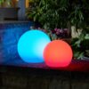 red and blue solar powered ball at night in garden
