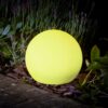 yellow solar powered ball at night in garden