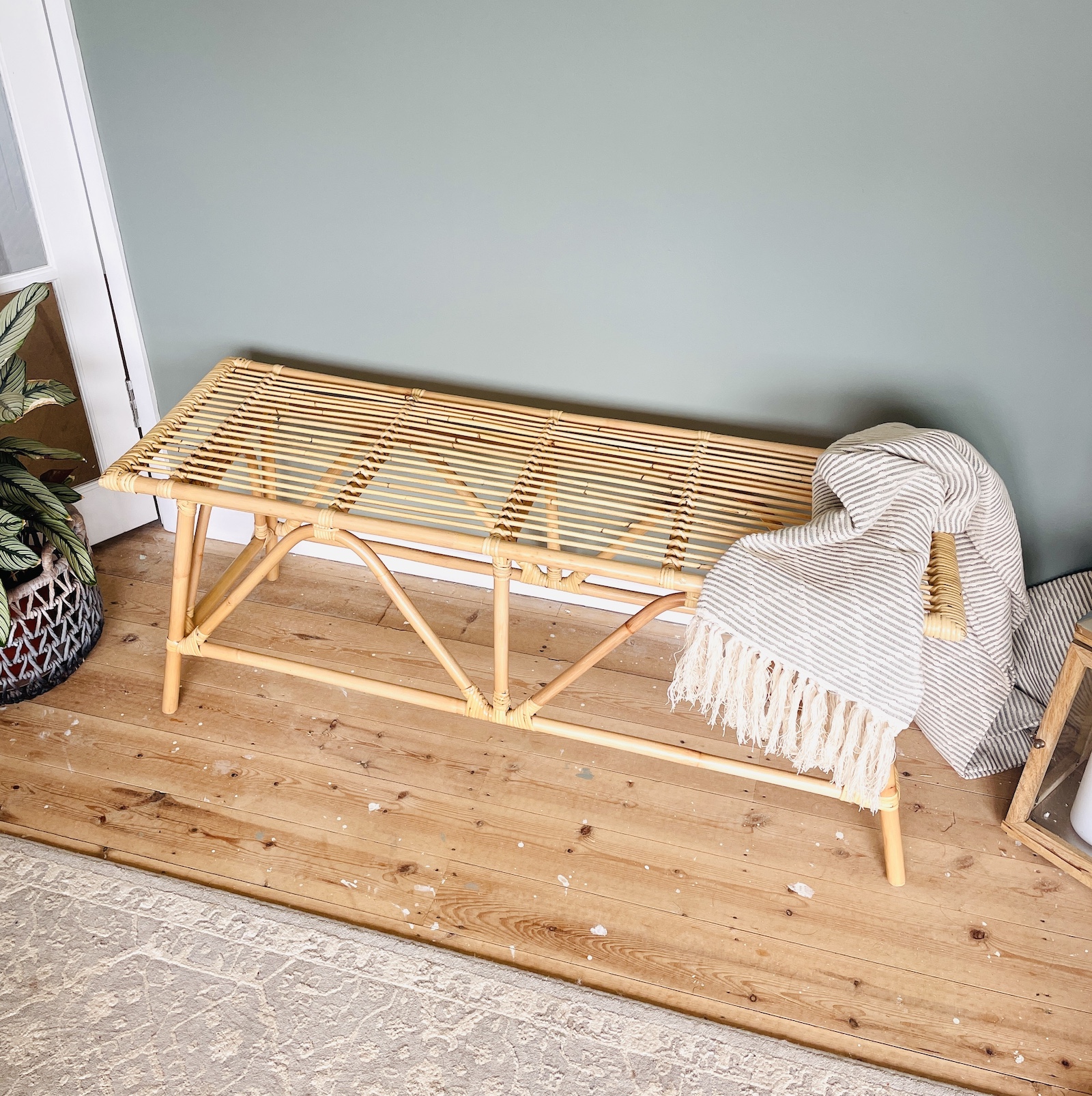 Bamboo bench on wood floor with throw