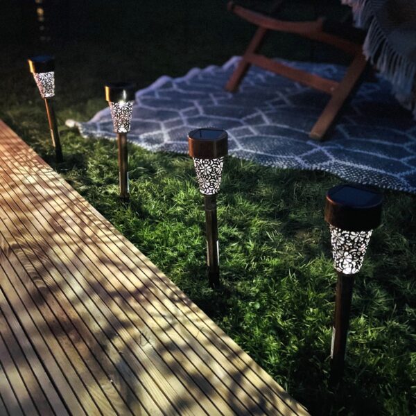 solar powered outdoor lights at night by decking with rug and wood armchair