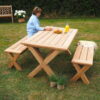 wooden garden dining set with woman sat at table on grass