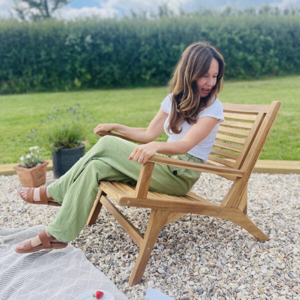 girl sat on garden arm chair wood