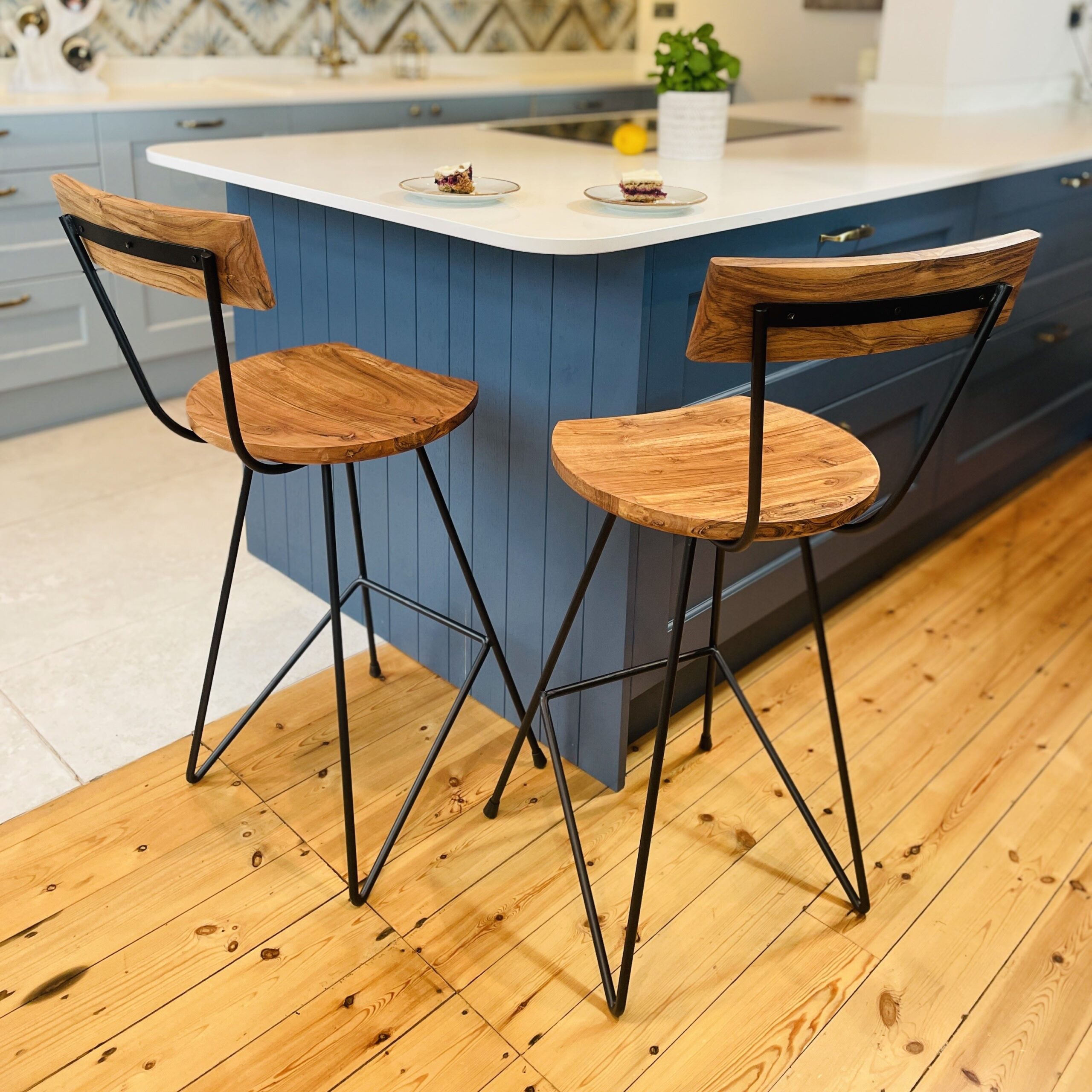 Two industrial bar stools in front of blue kitchen island