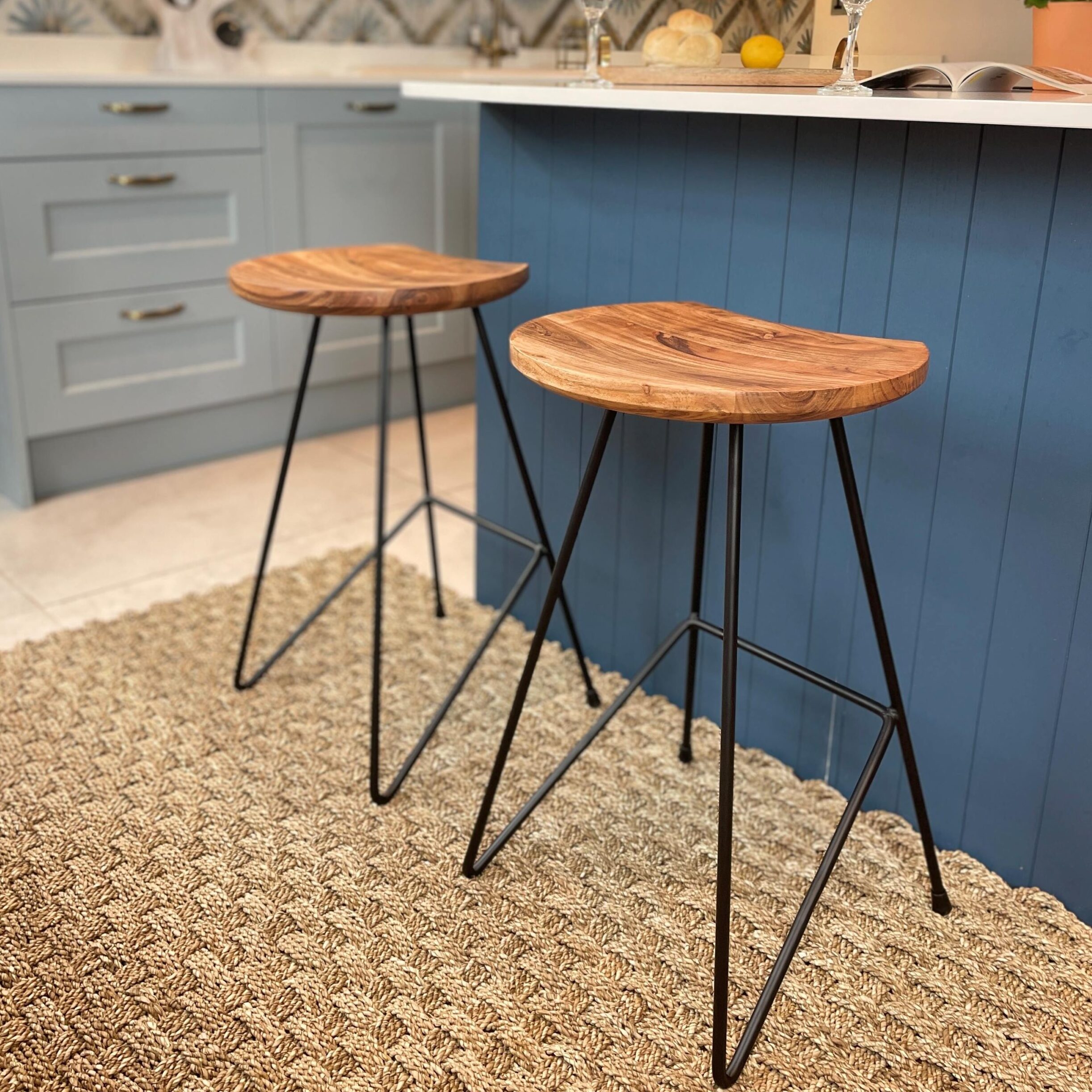 Industrial bar stools in kitchen in front of blue kitchen island