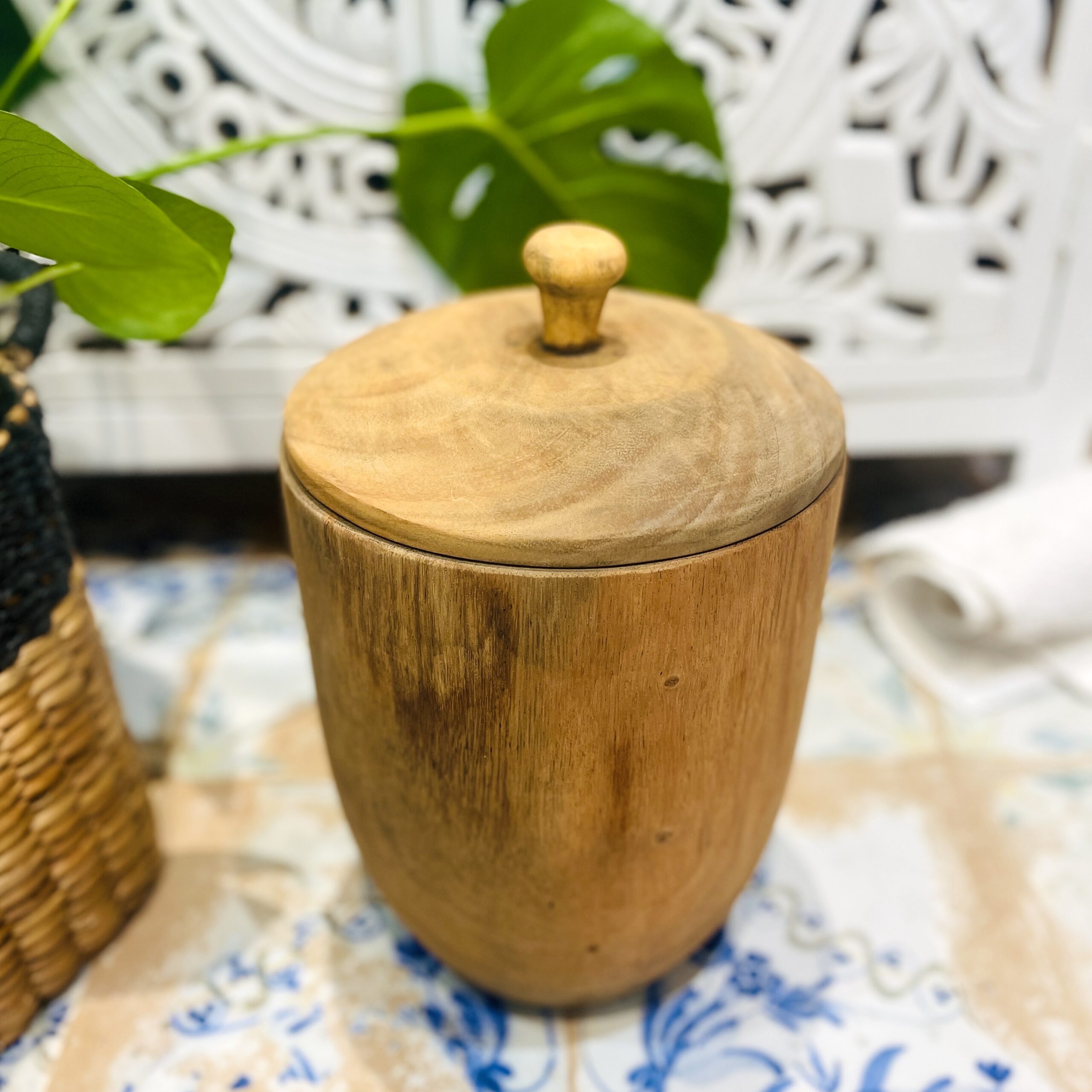 Small wooden pot on tiled floor with plant