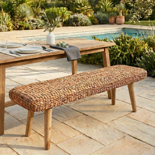 wicker bench in the garden at a dinner table by poolside