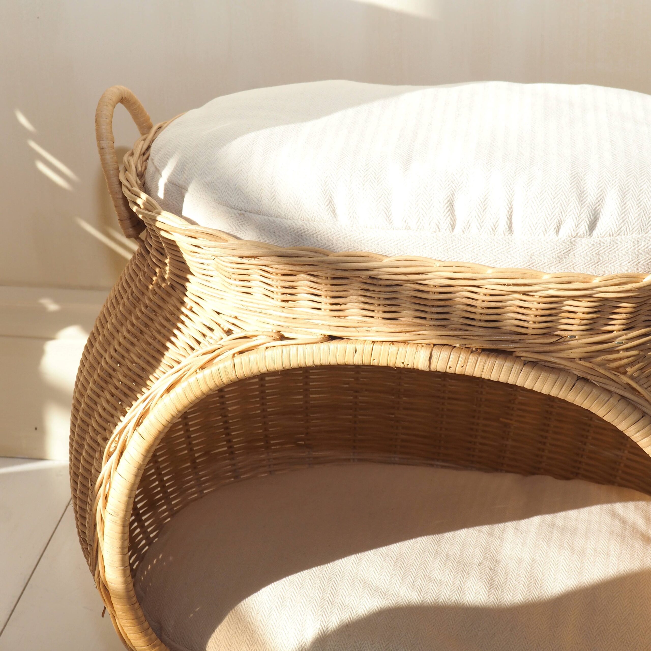 Close up of wicker cat basket with cream cushions