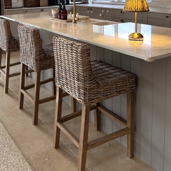 natural rattan kitchen stools at kitchen island on stone floor