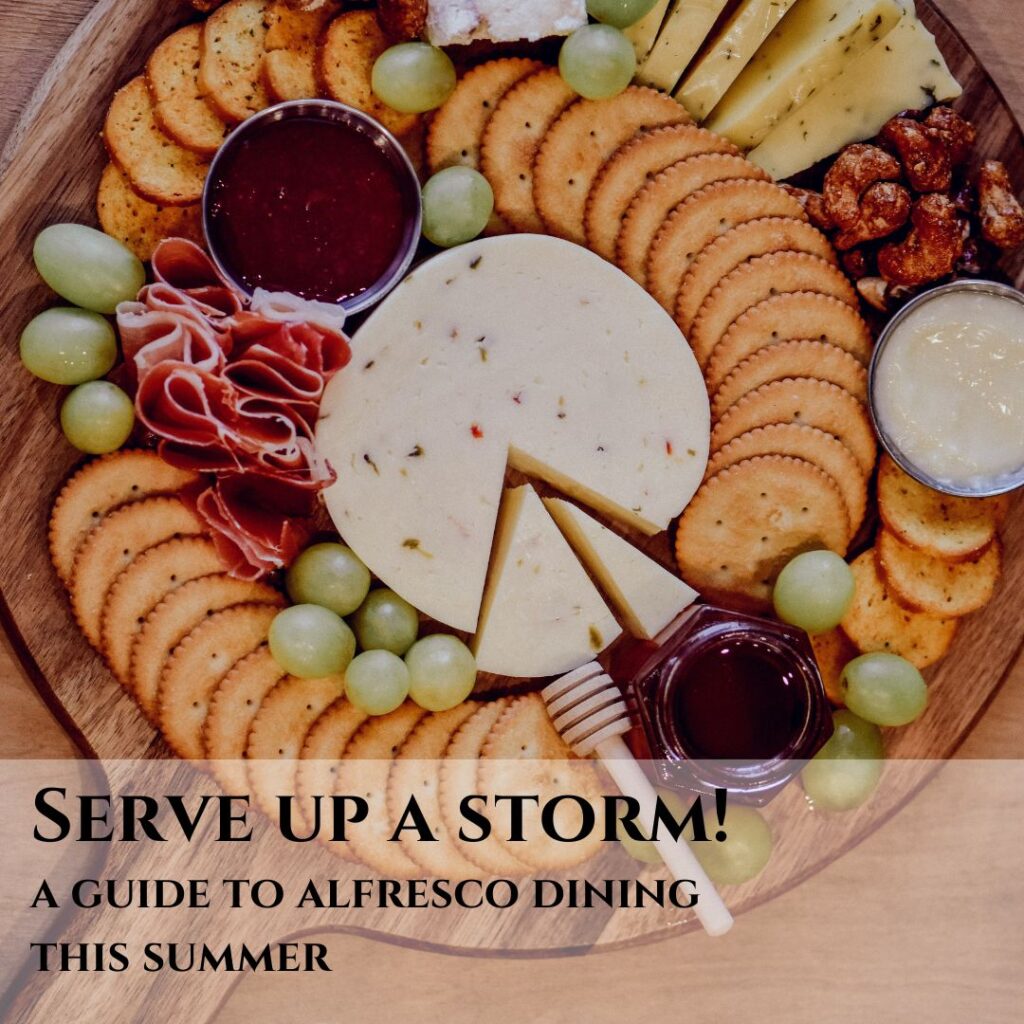 Serving platter of cheeses and crackers on a round wooden serving board alfresco dining