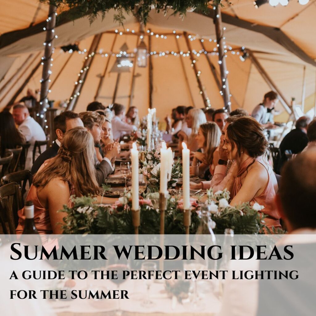 People in a wedding marquee at a table with candles and foliage