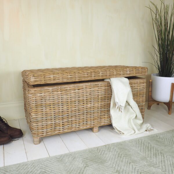 Wicker storage box with white plant pot on floor with leather boots