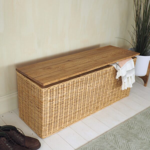 rattan shoe storage bench in hallway with green rug and plant