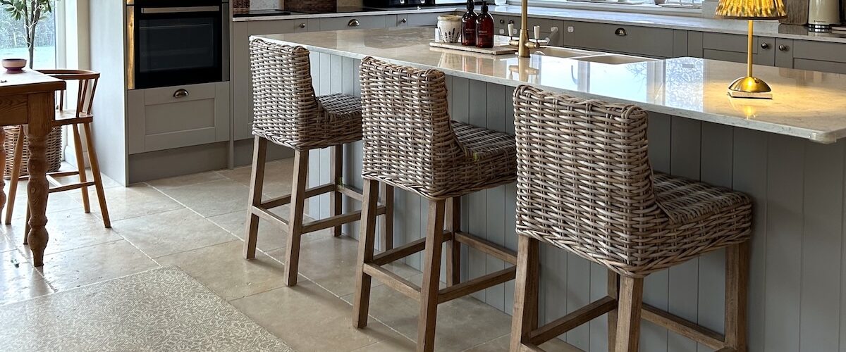 farmhouse kitchen with rattan bar stools at kitchen island