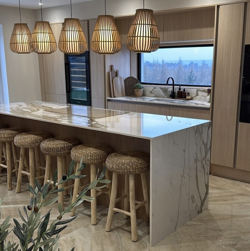 large kitchen with hanging lights and wicker kitchen stools