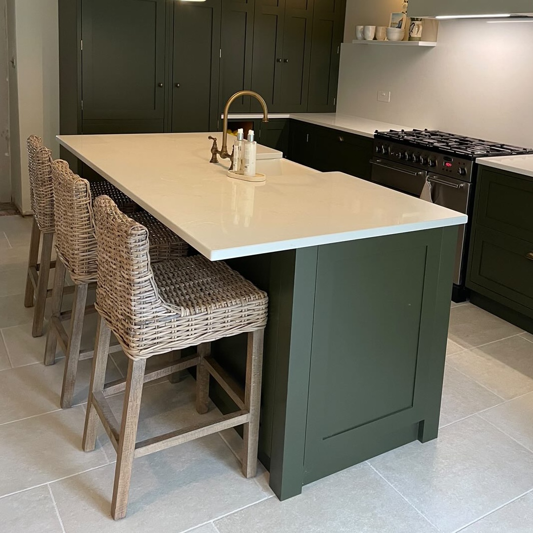 dark green kitchen island with rattan kitchen stools