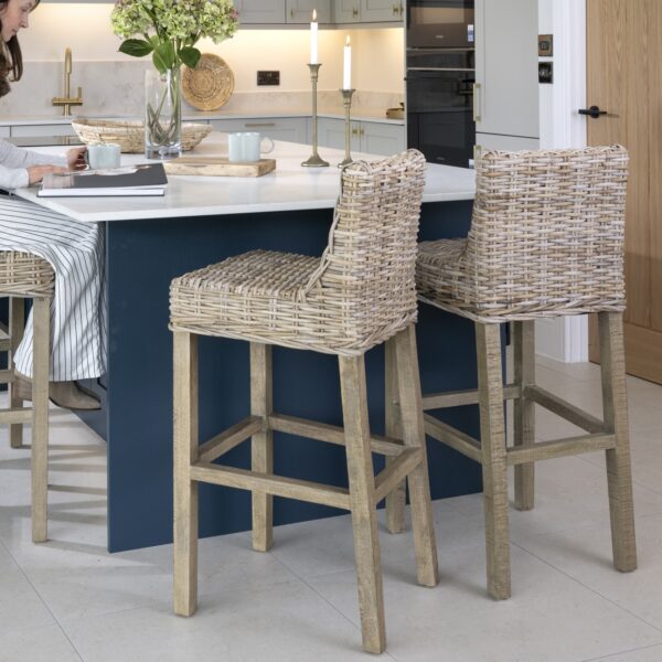 Wicker kitchen stools at kitchen island with women reading a book